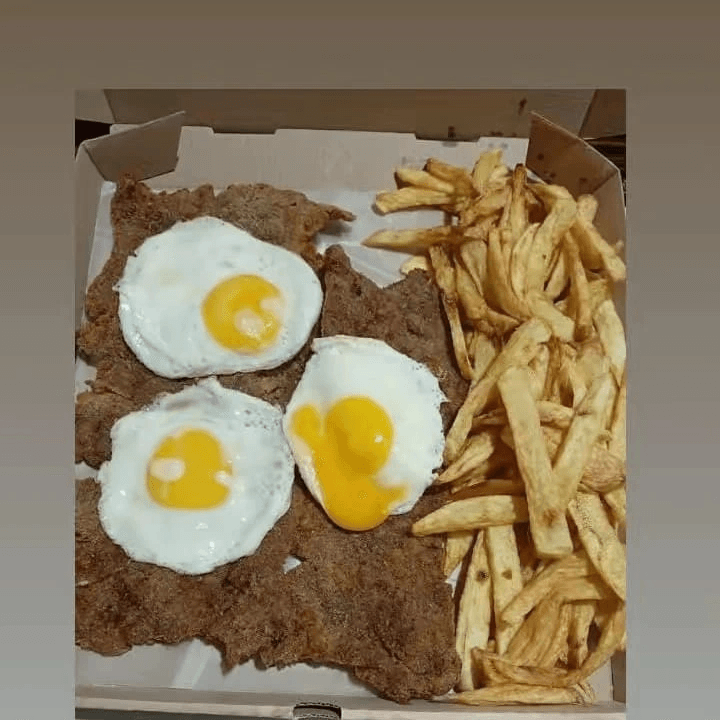 Bife à milanesa com ovo frito e batatas para compartilhar