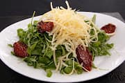 Ensalada de rucula con tomates secos y parmesano